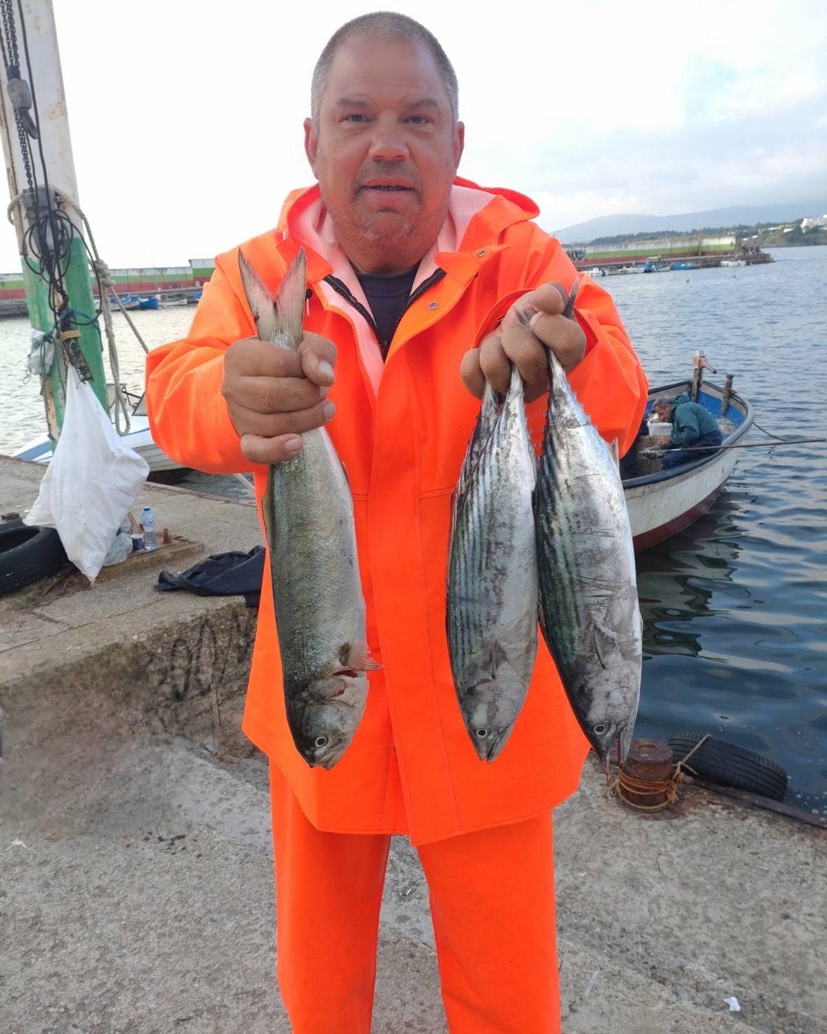 Мъж в оранжев костюм с риба